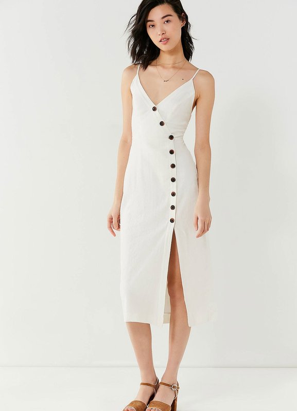 Asymmetric button arrangement on a white dress