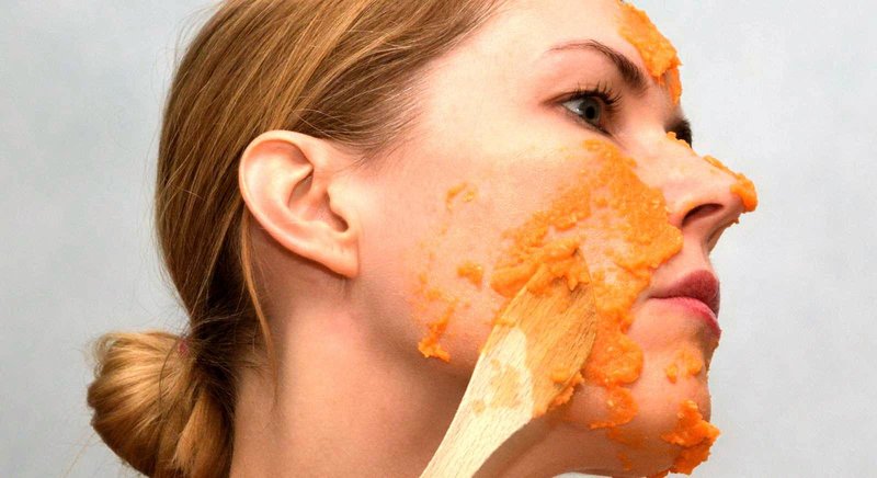 Girl puts a carrot mask on her skin