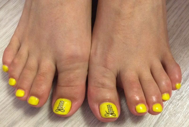 Yellow pedicure with rhinestones