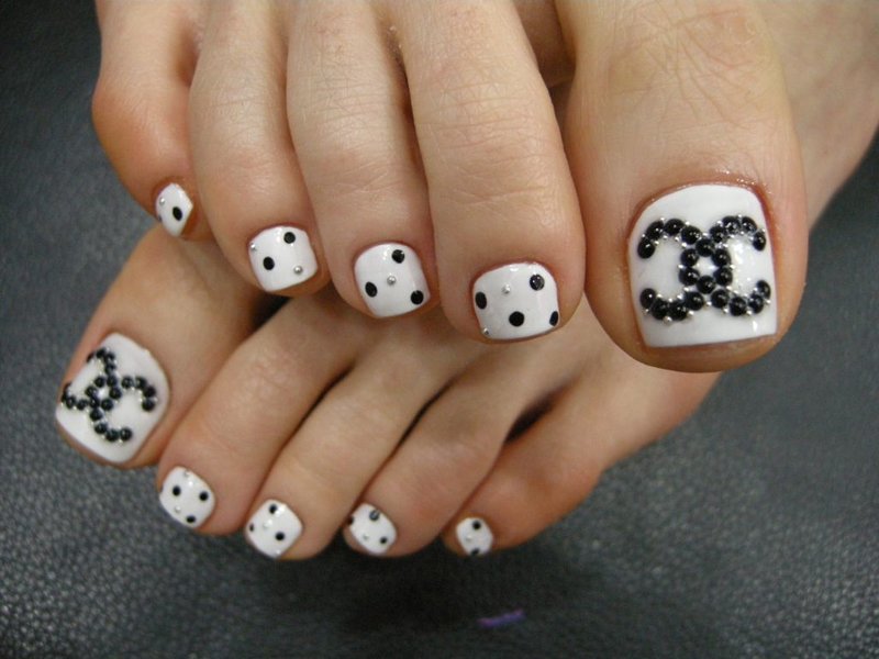 White pedicure with black rhinestones