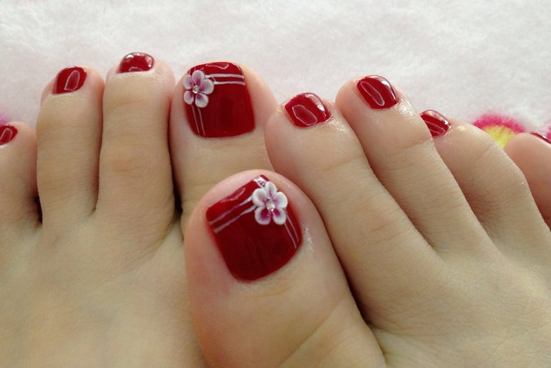 Pedicure red with a flower (modeling)