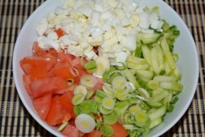 Fresh cucumber and tomato salad with egg and leek