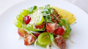 Tasty salad with grapes, meat and arugula in oriental style