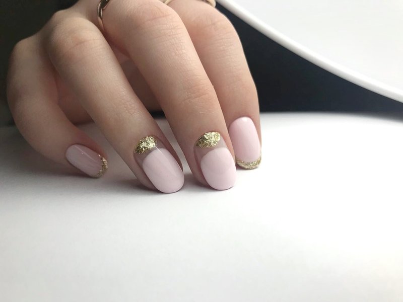 Nude style manicure with golden holes and a French jacket.