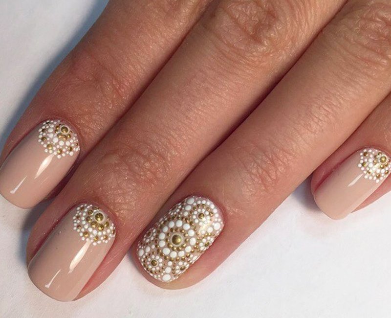 Nude manicure with golden white dot pattern