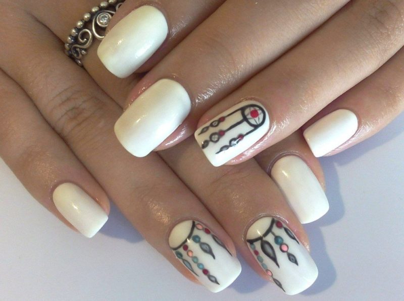 Minimalist beige manicure with dream catchers.