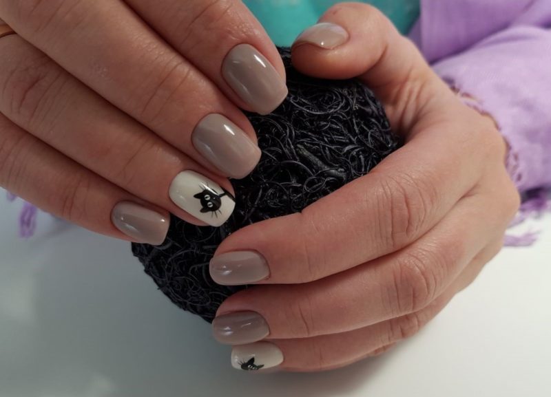 Nude manicure with a cat pattern