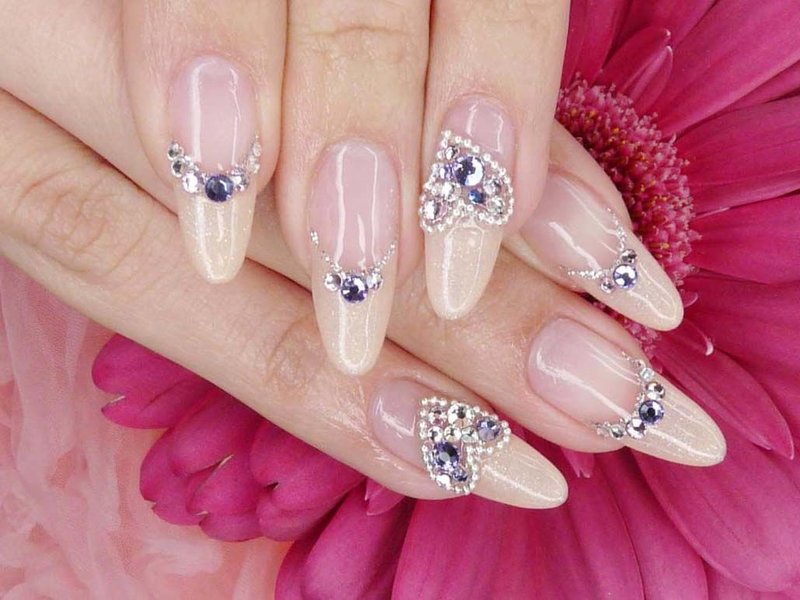 Nude manicure with multi-colored rhinestones and heart.