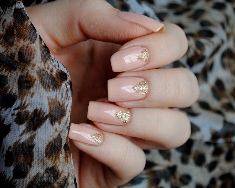 Gold manicured triangular nails