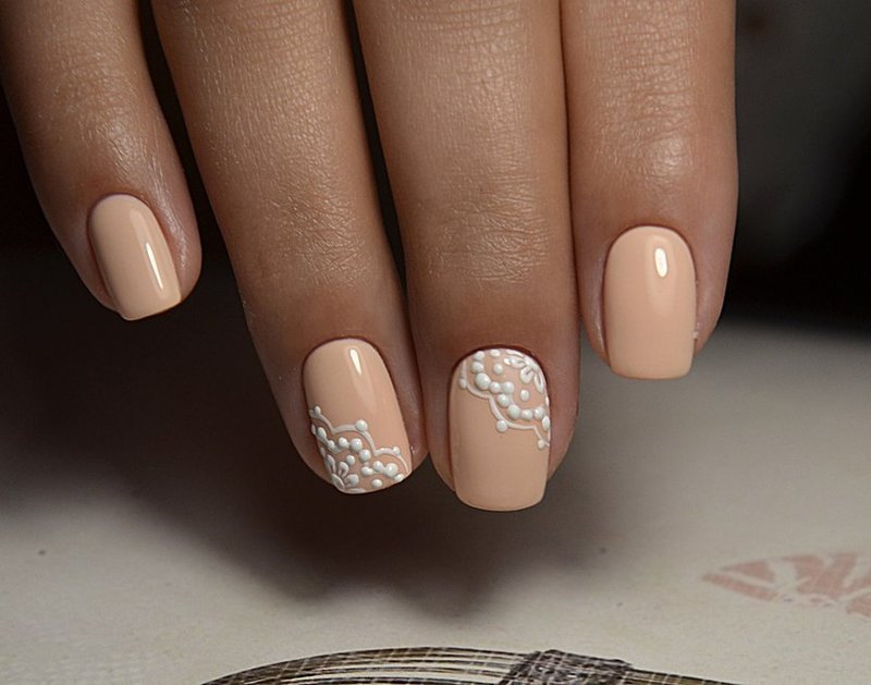 Orange-beige manicure with white lace.