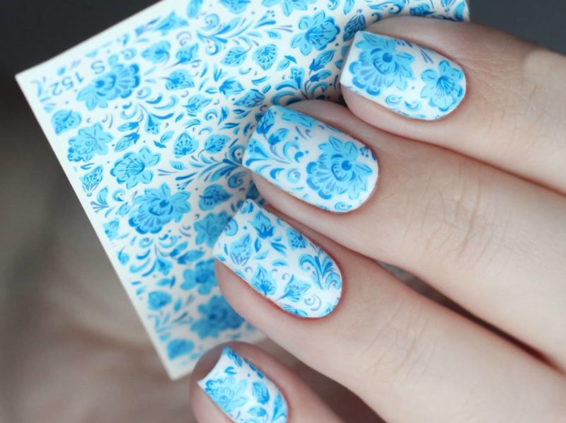 Nail design with blue slides on a white background