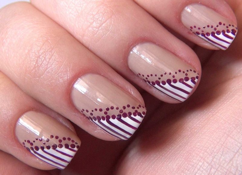 Minimalist nude manicure with dots and stripes.