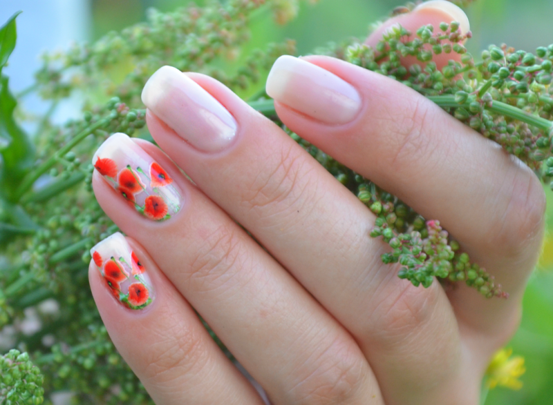 Nude manicure with stickers in the form of poppies.