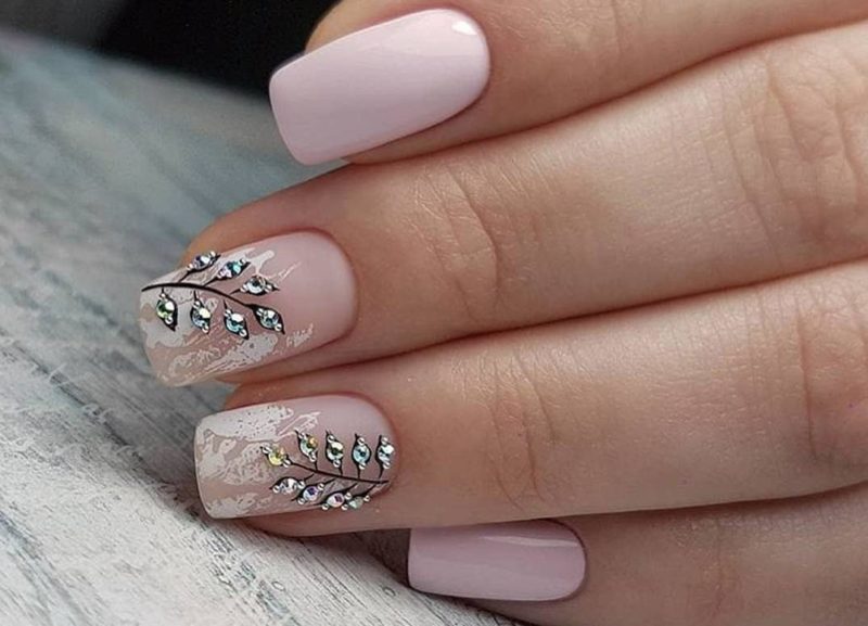 Pink manicure with floral pattern and rhinestones.