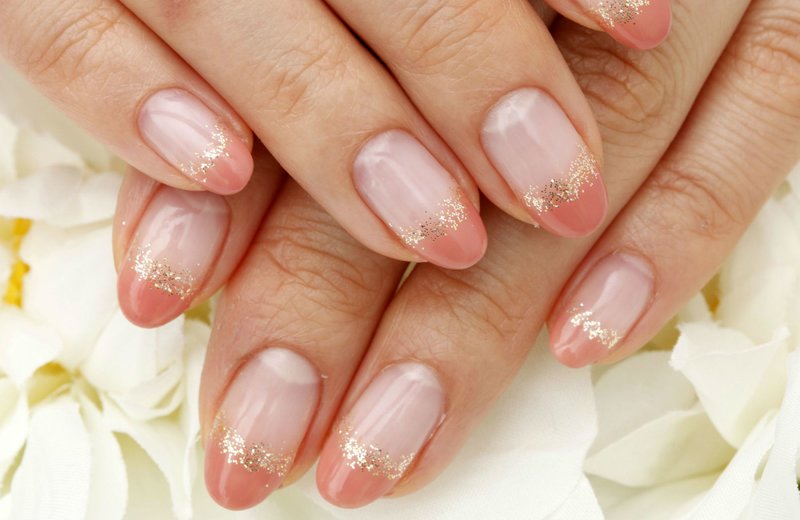 Nude nails with orange jacket and gold sequins