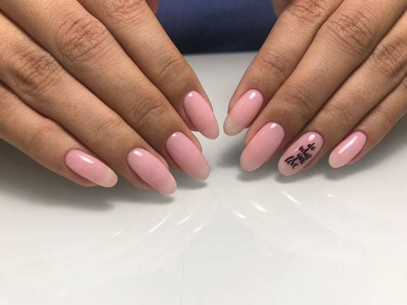 Delicate pink manicure with the inscription.