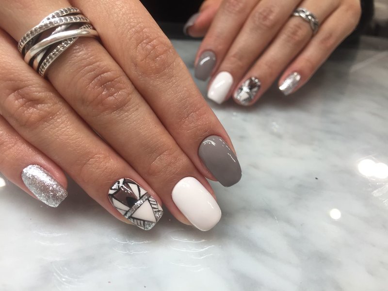 Manicure nude with sequins and fashionable abstraction.