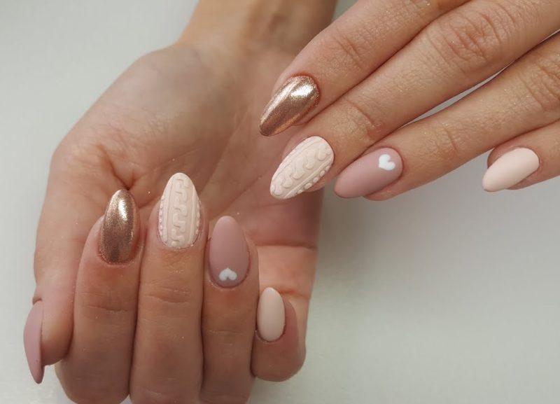 Nude manicure with a matte finish, gold glitter and volumetric pattern.