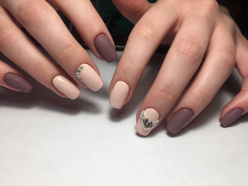 Nude matte nails with a heart of rhinestones and broths