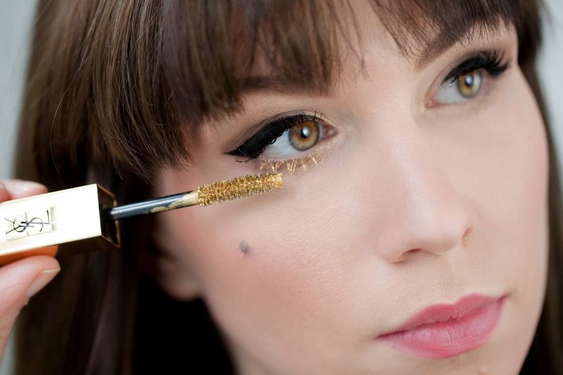 Makeup with arrows and golden mascara on the lower eyelashes