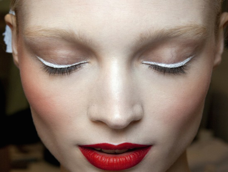 Minimalistic makeup with trendy white arrows and red lipstick.