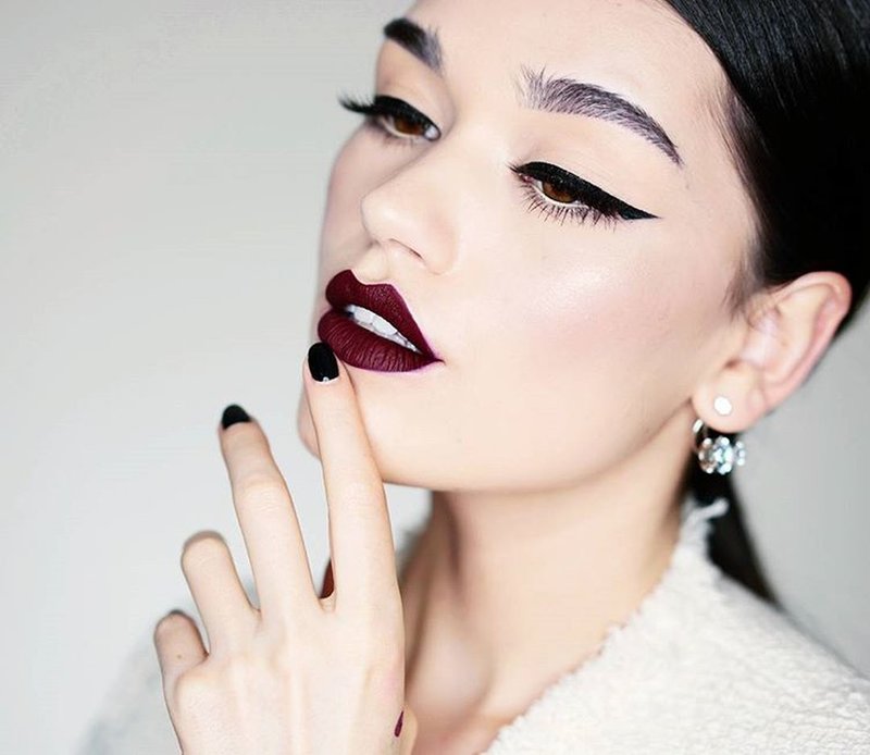 Grunge style make-up with arrows and dark lipstick.