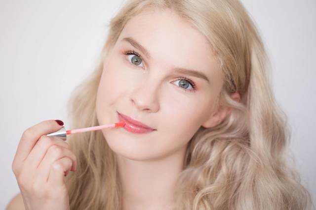 The last stage of makeup - applying gloss