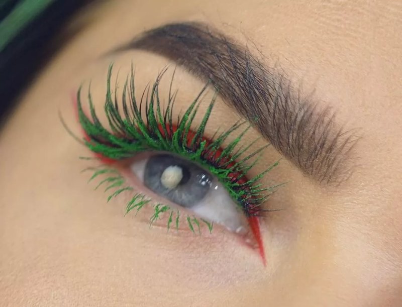 An unusual combination of red arrows and green eyelashes in makeup