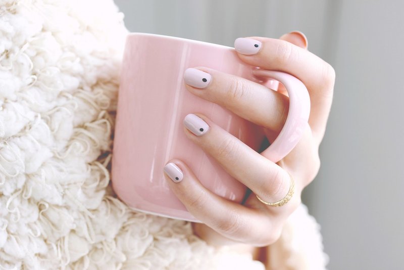 Minimalist manicure with black dots.