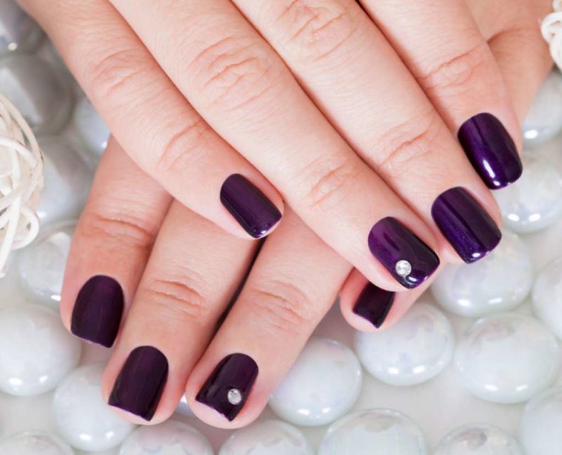 Manicure with shellac and stone in violet shades