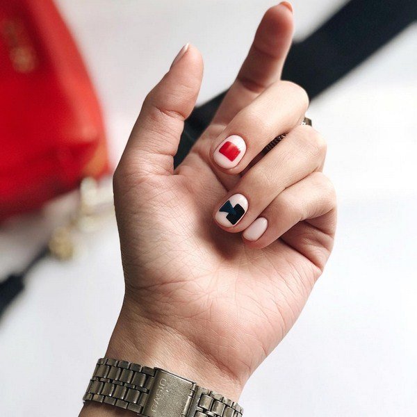 Geometric manicure in black and red colors on a nude basis.