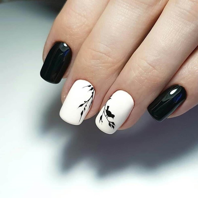 Stylish black and white manicure with a spring composition