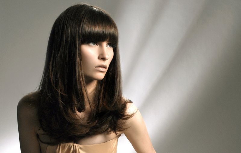 Girl with a haircut ladder with a straight bang on long hair