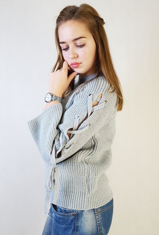 Girl in a sweater with ties along the sleeves