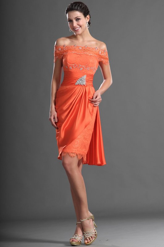 Girl in an orange cocktail dress with bare shoulders and rhinestones