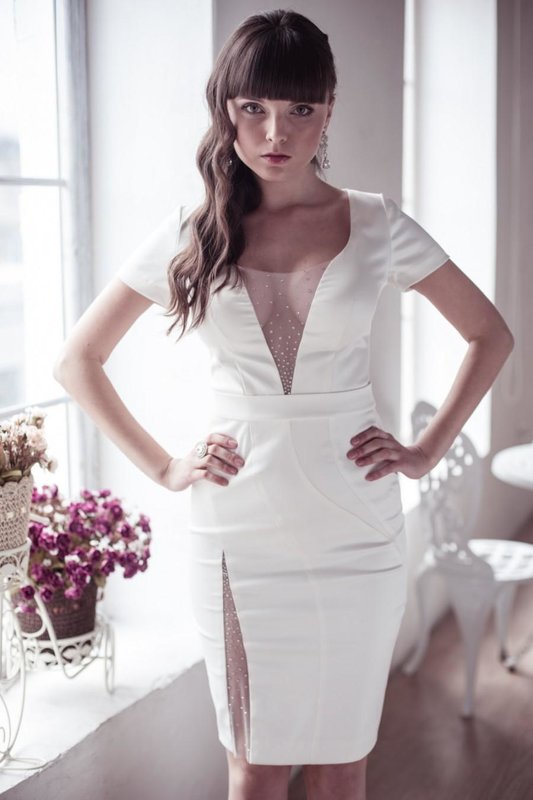 Girl in a white cocktail dress with a deep neckline