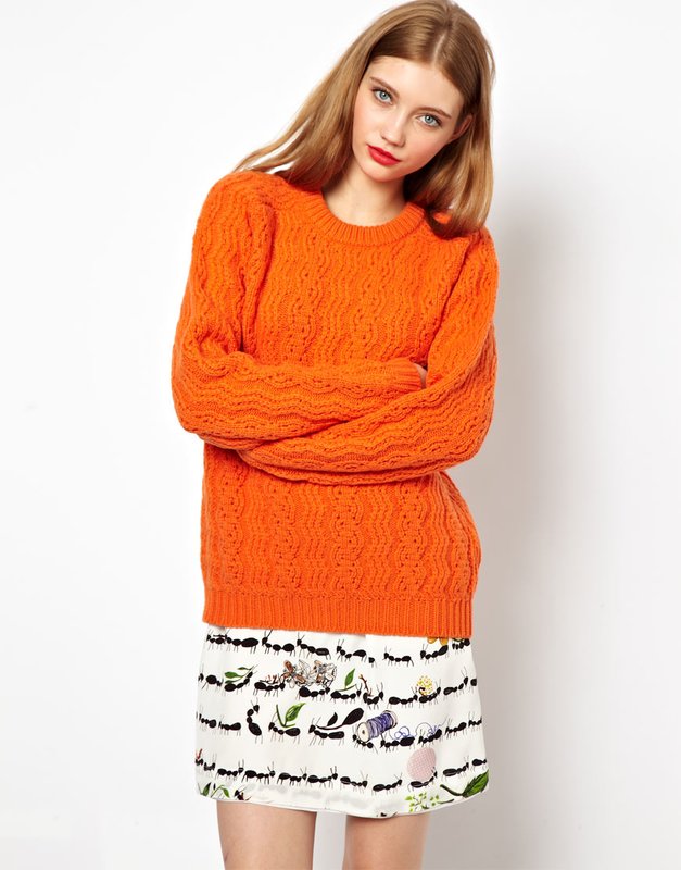 Girl in an orange sweater and skirt