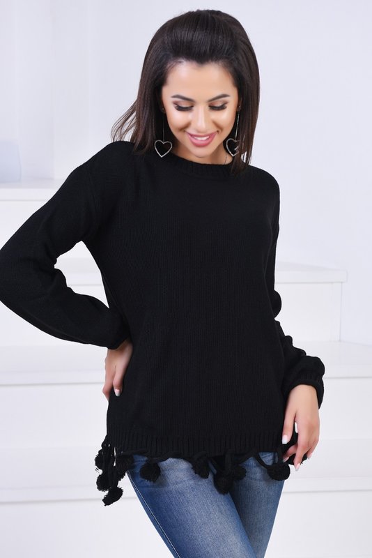 Girl in a black sweater with pompoms on the hem