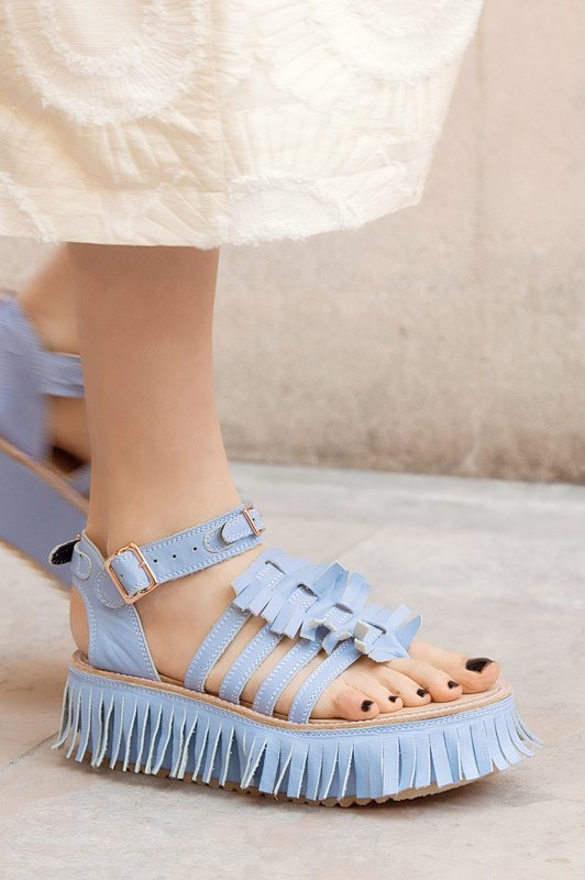 Girl in sandals with a fringe along the edge of the sole