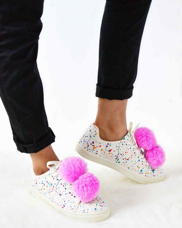 Girl in sneakers with pompons.