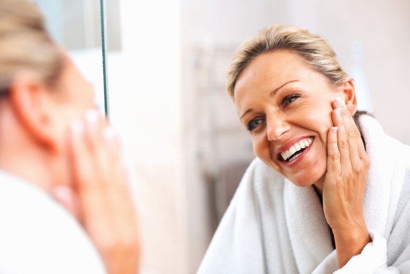 Woman moisturizes her face