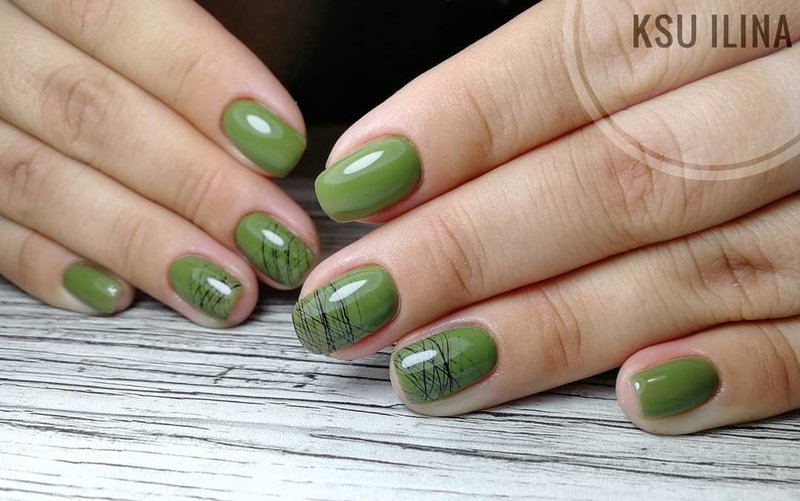 Trendy olive manicure with spider web design.