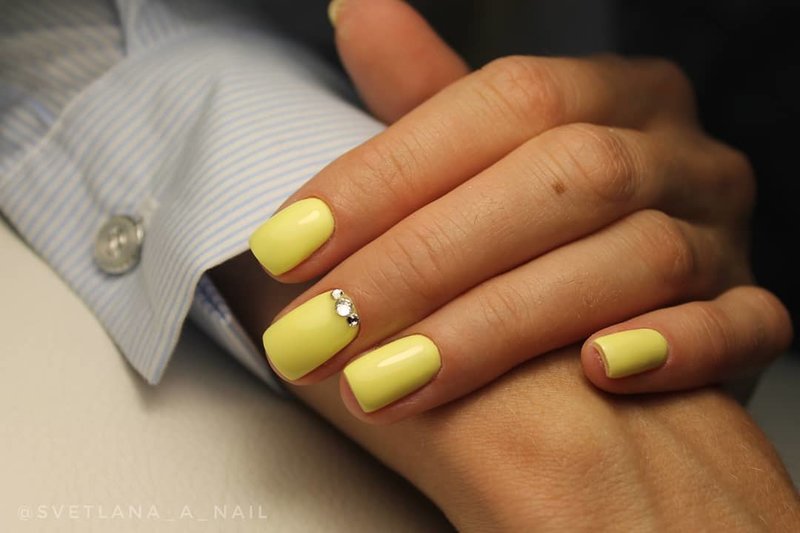 Delicate yellow manicure with rhinestones.