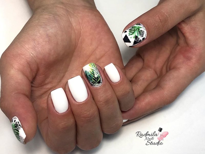 White manicure with a tropical pattern