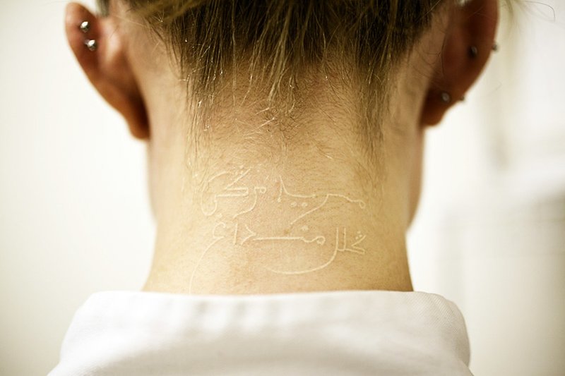 White tattoo on the back of the head