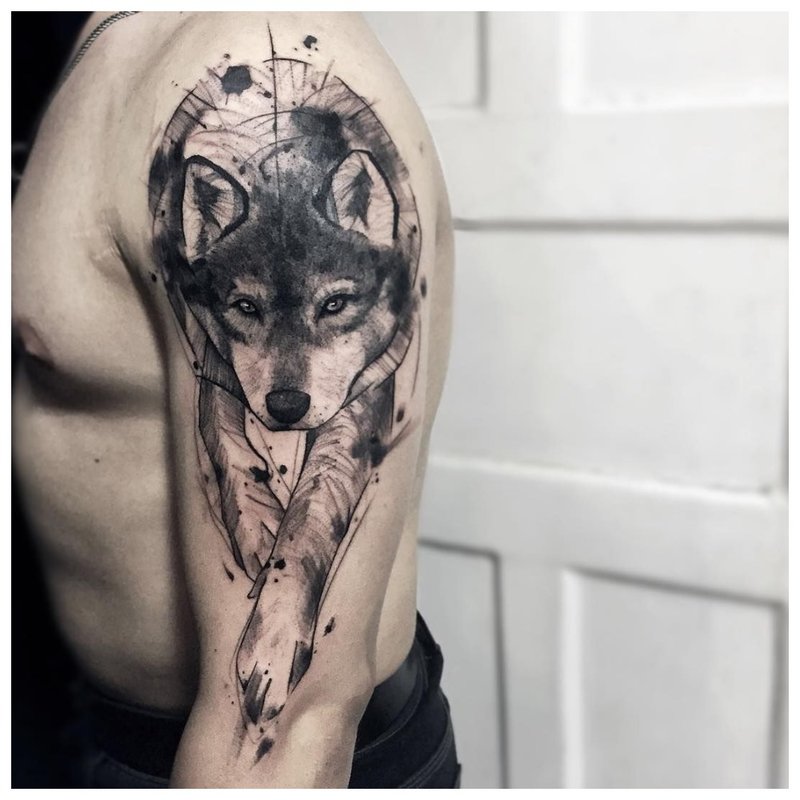 Cute wolf cub - tattoo on a man’s shoulder