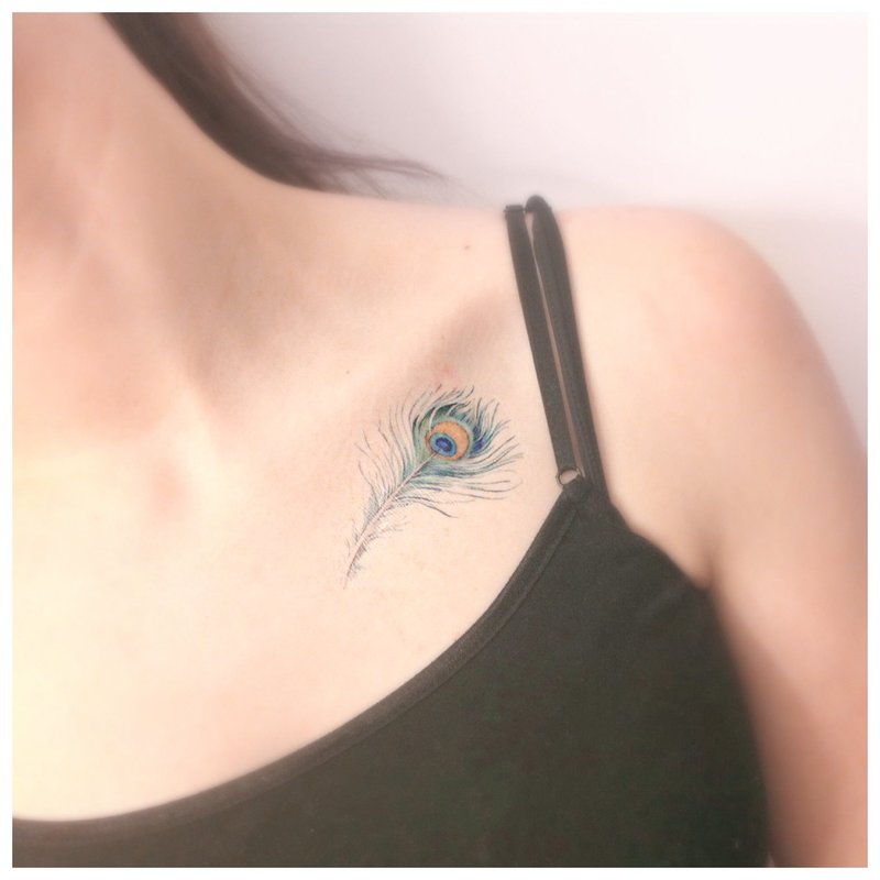 Original bright feather tattoo on the clavicle