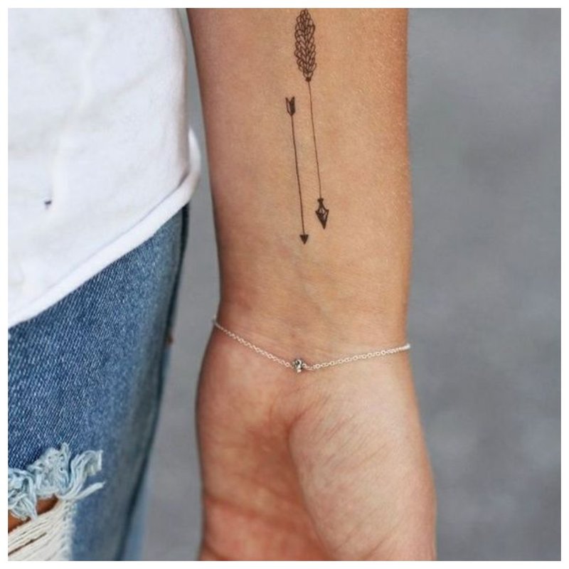 Delicate unusual arrow tattoo