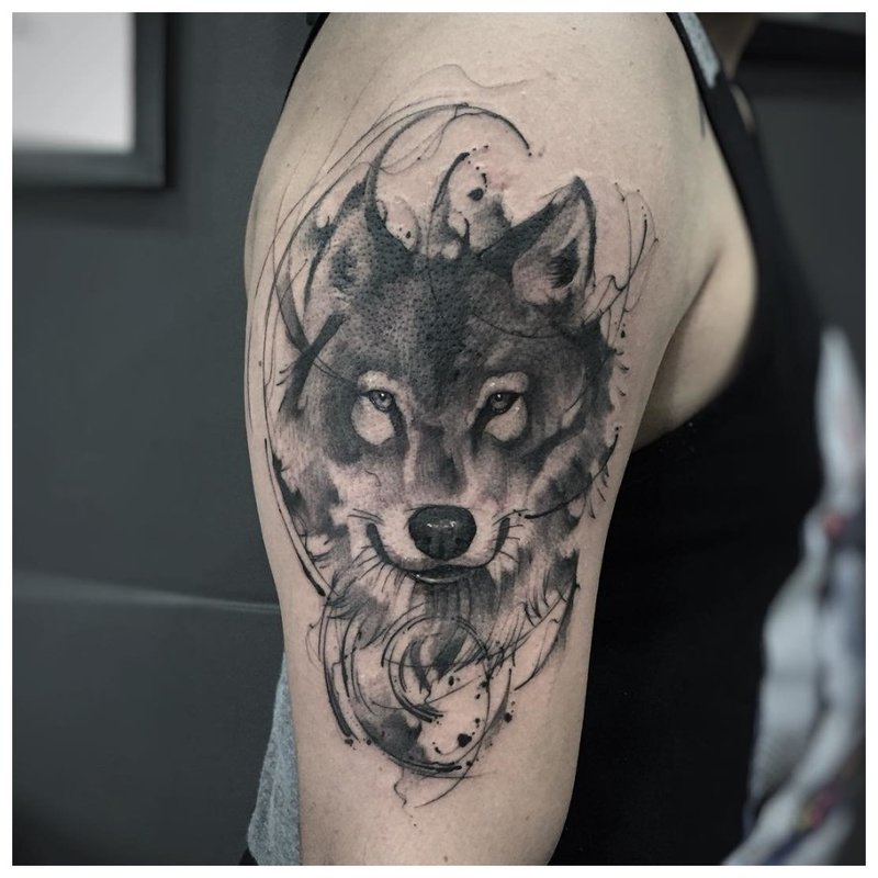 Wolf face - tattoo on a man’s shoulder