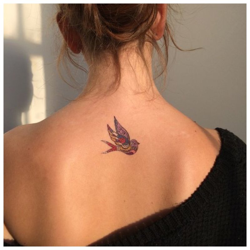 Bird - tattoo on the back of a girl